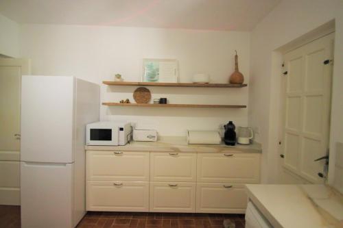 a kitchen with a white refrigerator and a microwave at Chalet CasaTuris en Urb. La Font Sant Joan d´Alacant CH102 in San Juan de Alicante