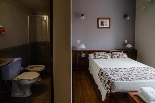 a bedroom with a bed and a bathroom with a toilet at Munay San Salvador de Jujuy in San Salvador de Jujuy