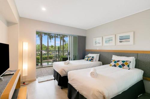 a hotel room with two beds and a balcony at Peppers Plunge Pool Perfection 2br spa suite in Kingscliff