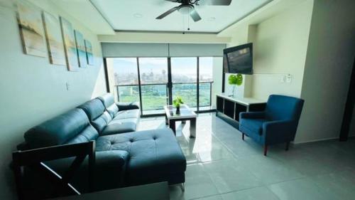 a living room with a blue couch and a blue chair at Luxury Condo Downtown Rosarito in Rosarito