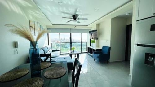 a living room with a couch and a table with chairs at Luxury Condo Downtown Rosarito in Rosarito