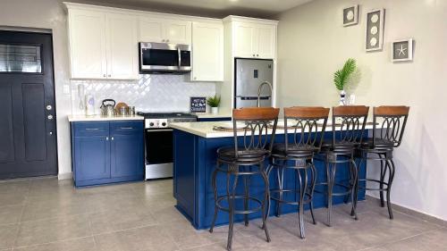 a kitchen with a blue island with bar stools at Luxury Condo Downtown Rosarito in Rosarito