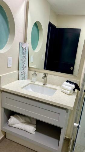 a bathroom with a sink and a mirror at Luxury Condo Downtown Rosarito in Rosarito