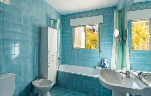 Bedmar的住宿－3 Bedroom Nice Home In Bedmar，蓝色瓷砖浴室设有水槽和卫生间
