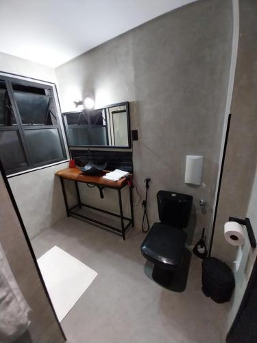 a bathroom with a desk and a chair and a mirror at FLAT PALLADIUM - de frente in São Vicente