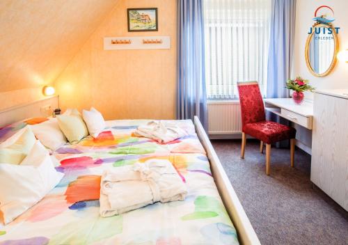 a hotel room with a bed with towels on it at Haus Petra 133 - Ferienwohnung 3 in Juist