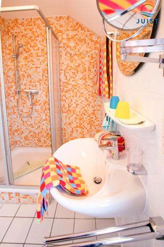 a bathroom with a shower and a white sink at Haus Petra 134 - Ferienwohnung 4 in Juist