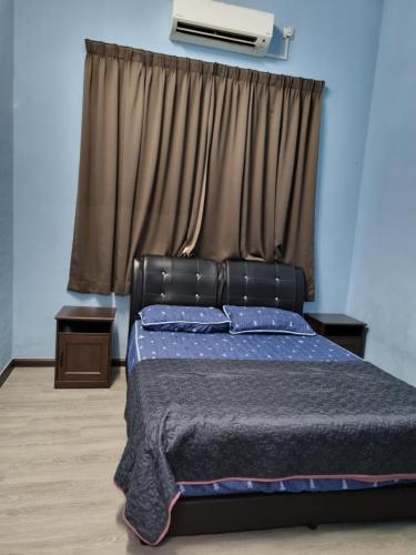 um quarto com uma cama e uma janela com ar condicionado em E.R. BUDGET INN em Kota Bharu
