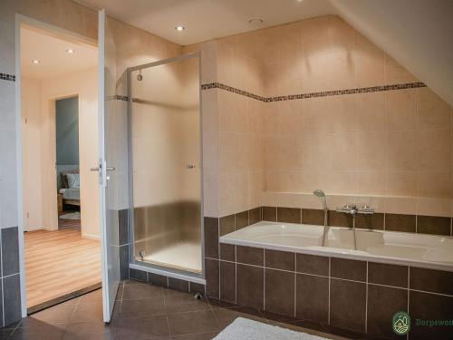 a large bathroom with a tub and a shower at Luxurious holiday home in the middle of the Leenderbos nature reserve, near quiet Leende in Leende