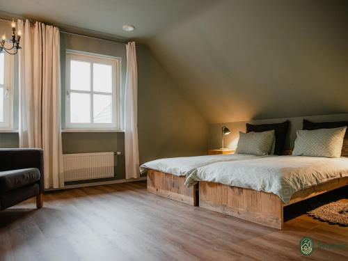 a bedroom with a large bed and a window at Country house next to a nature reserve in Leende