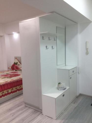 een witte kamer met een bed en een witte kast bij Квартира Юбилейный in Alma-Ata
