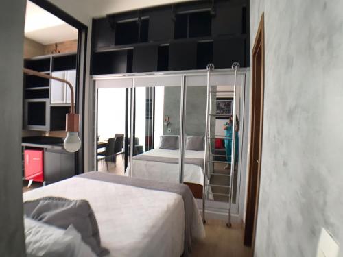 1 dormitorio con 2 camas y ventana grande en Maravilhoso Loft vista mar OCEANVIEW en Niterói