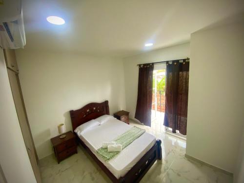 niewielka sypialnia z łóżkiem i oknem w obiekcie Cómoda y linda casa en mompox w mieście El Socorro