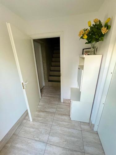 a hallway with stairs and a vase of flowers at CENTRO House in Alytus
