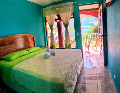 a bedroom with a bed with a teddy bear on it at Hotel Adulam in San Pedro La Laguna