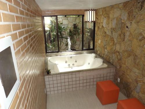 uma banheira na casa de banho com uma janela em Pousada Pé da Tartaruga em Teresópolis