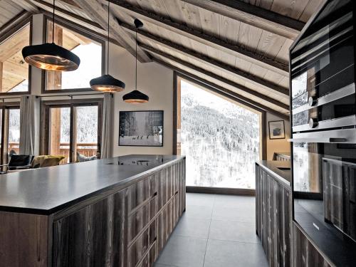 - une cuisine avec un grand comptoir et de grandes fenêtres dans l'établissement Penthouse luxueux avec 5 chambres et conciergerie 5* à Méribel - FR-1-613-29, à Méribel