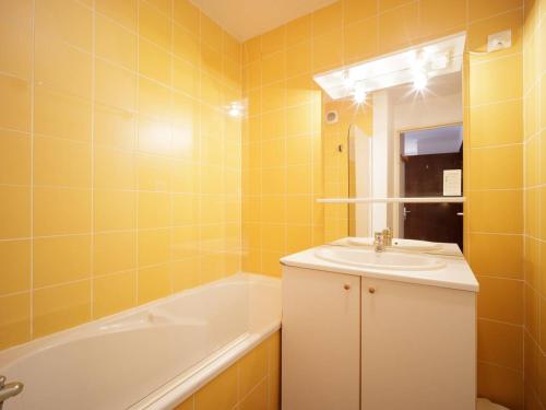 a yellow bathroom with a sink and a bath tub at Appartement cosy pour 6 personnes avec balcon, parking et accès aux pistes - FR-1-695-9 in Germ