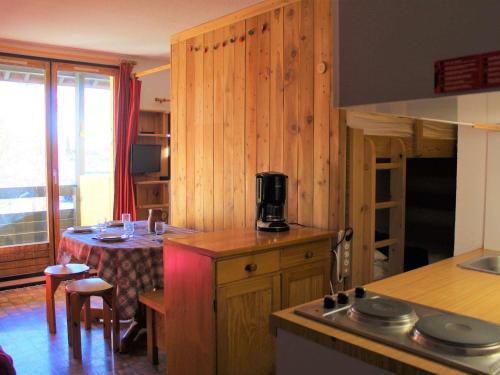 une cuisine avec une table et un comptoir dans l'établissement Studio cosy à Vars Sainte Marie, 4 couchages, balcon sud, à 300m des pistes et commerces - FR-1-330B-202, à Vars