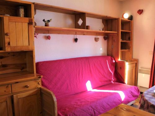 - un canapé dans une chambre avec une couverture rose dans l'établissement Studio cosy à Vars Sainte Marie, 4 couchages, balcon sud, à 300m des pistes et commerces - FR-1-330B-202, à Vars