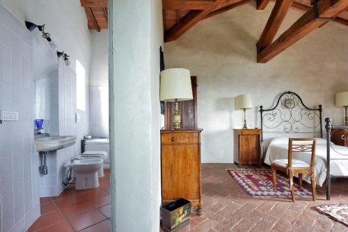 a bedroom with a bed and a sink and a toilet at Castello di Bibbione in San Casciano in Val di Pesa