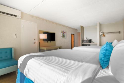 a bedroom with a large white bed and a blue chair at Inn on Destin Harbor, an Ascend Collection Hotel in Destin