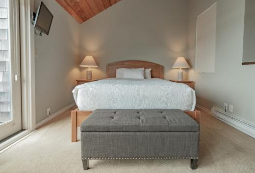 a bedroom with a bed with a ottoman and two lamps at Embarcadero Resort in Newport
