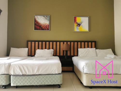 two beds sitting next to each other in a room at Gold Coast Morib Resort in Banting