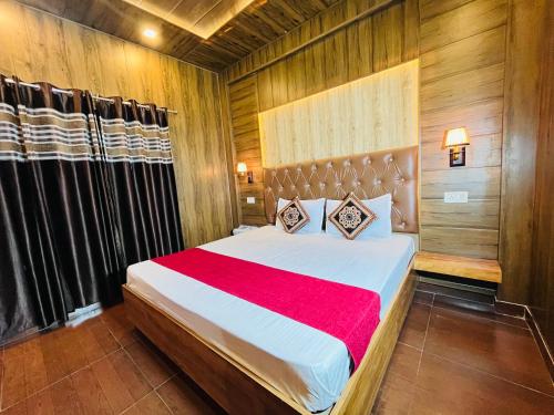 a bedroom with a large bed with a red blanket at Vanshika homes Near mall road in Kasauli