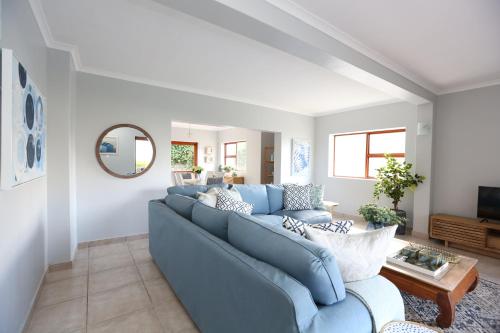 a living room with a blue couch and a table at Above & Beyond Houtbay in Hout Bay