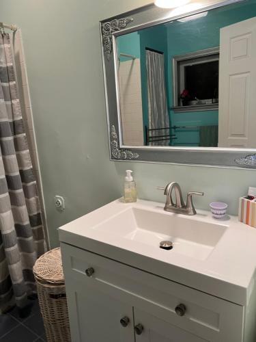 uma casa de banho com um lavatório branco e um espelho. em Beautiful Victorian house, Room em Boston