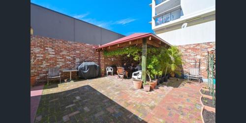 a brick building with a patio with a pavilion at Emu Backpackers Perth - note - Valid Passport required for check in in Perth