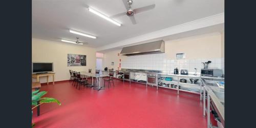 a large room with a red floor in a kitchen at Emu Backpackers Perth - note - Valid passport required to check in in Perth