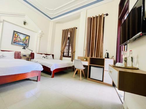 um quarto de hotel com duas camas e uma televisão em EVA Hotel em Hue