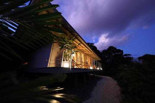 a building with a balcony with lights on it at 泊まれるアートミュージアム 琉球ヴィラ in Tatsugo