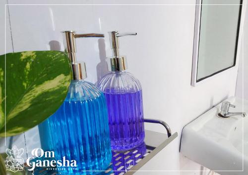 two glass vases sitting on a shelf next to a sink at Om Ganesha in Palolem