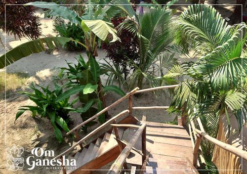 a wooden staircase in a garden with plants at Om Ganesha in Palolem