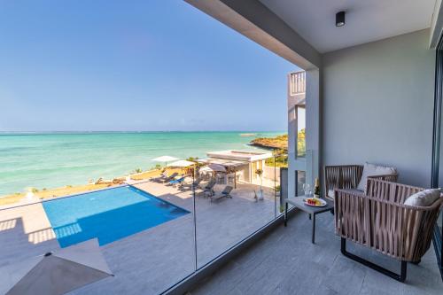 a room with a view of the ocean and a swimming pool at Villa Bluu Zanzibar in Jambiani