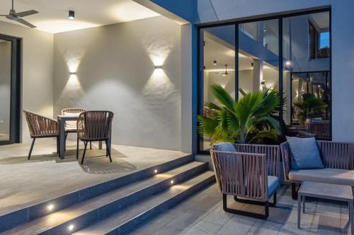 a patio with chairs and a table and a table and chairs at Villa Bluu Zanzibar in Jambiani