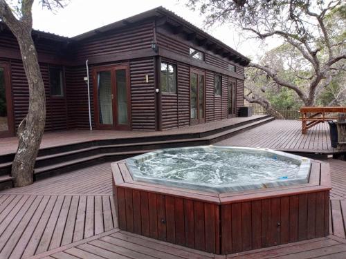 a hot tub on the deck of a house at Blyde River Cabins in Hoedspruit