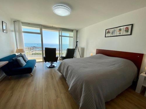 a bedroom with a bed and a view of the ocean at Studio Quiberon, 1 pièce, 3 personnes - FR-1-478-39 in Quiberon