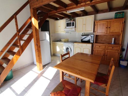 une cuisine avec une table en bois et un escalier en bois dans l'établissement Maison 3 pièces + mezzanine, proche plage à Dolus-d'Oléron, 4 couchages - FR-1-246A-90, à Dolus-d'Oléron