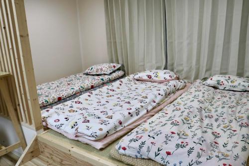 three beds sitting on a wooden platform in a room at attomi hostel in Sapporo