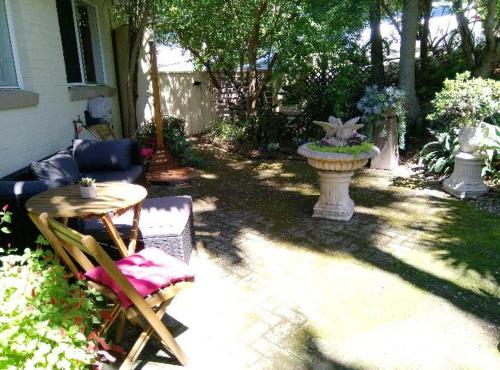 a patio with a table and chairs and a vase at Kincumber Guest Suite in Kincumber