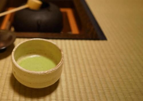 a green cup sitting on top of a table at Ryokan Tori in Kyoto