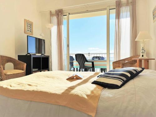 une chambre avec un grand lit avec vue sur l'océan dans l'établissement Appart 2 pièces avec terrasse au Lavandou, proche plage - FR-1-251-289, au Lavandou