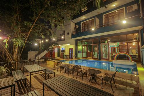 a hotel with a swimming pool and tables and chairs at Woodnest Summerside in Negombo