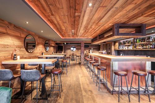 a restaurant with wooden walls and bar stools at No 8 Bed & Bar in Verbier