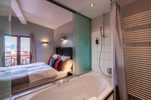 a bathroom with a tub and a bed and a window at No 8 Bed & Bar in Verbier