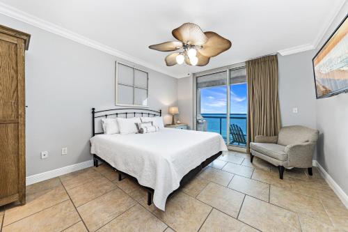 a bedroom with a bed and a chair and a window at 5 Portofino 1106 at Pensacola Beach in Pensacola Beach